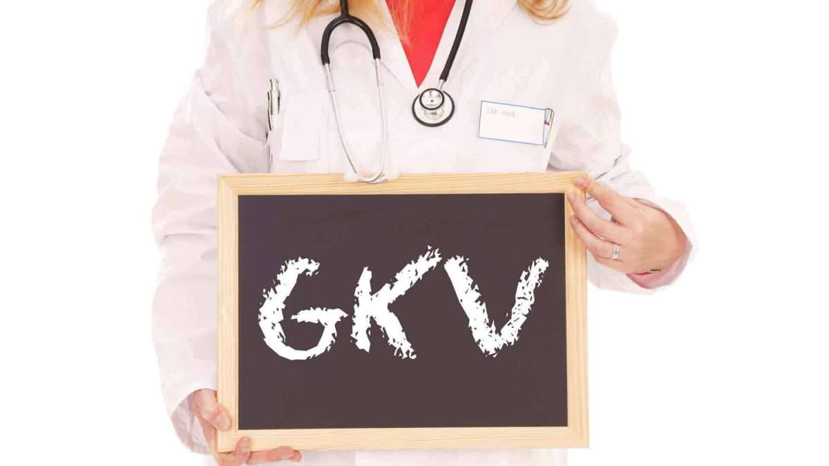 Ärztin in weißem Kittel hält eine Tafel mit der Aufschrift 'GKV'.