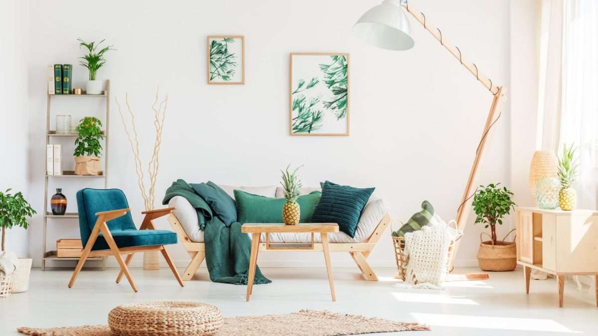 Ein modernes Wohnzimmer mit einem Sofa, einem Sessel und verschiedenen Pflanzen in Töpfen.