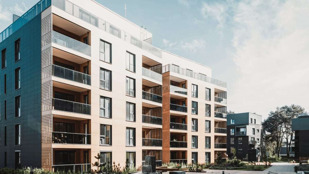 Mehrfamilienhaus mit mehreren Etagen und modernen Balkonen in einer urbanen Umgebung.