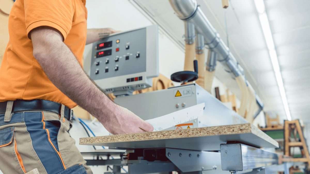 Ein Handwerker bedient eine Holzverarbeitungsmaschine in einer Werkstatt.